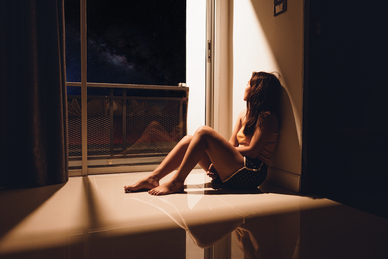 Woman sitting in dark room sad