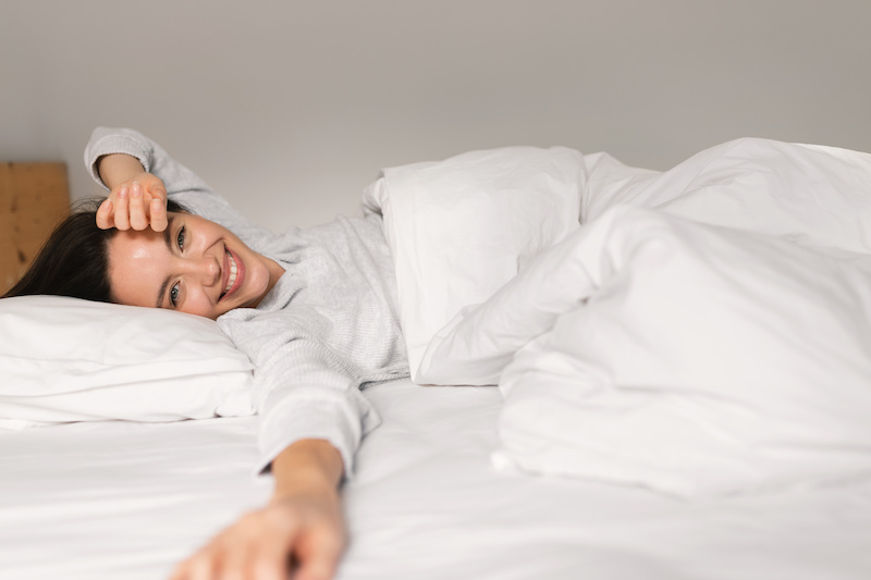 Smiling woman waking up refreshed and feeling great