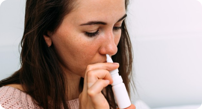Woman using nasal spray medication